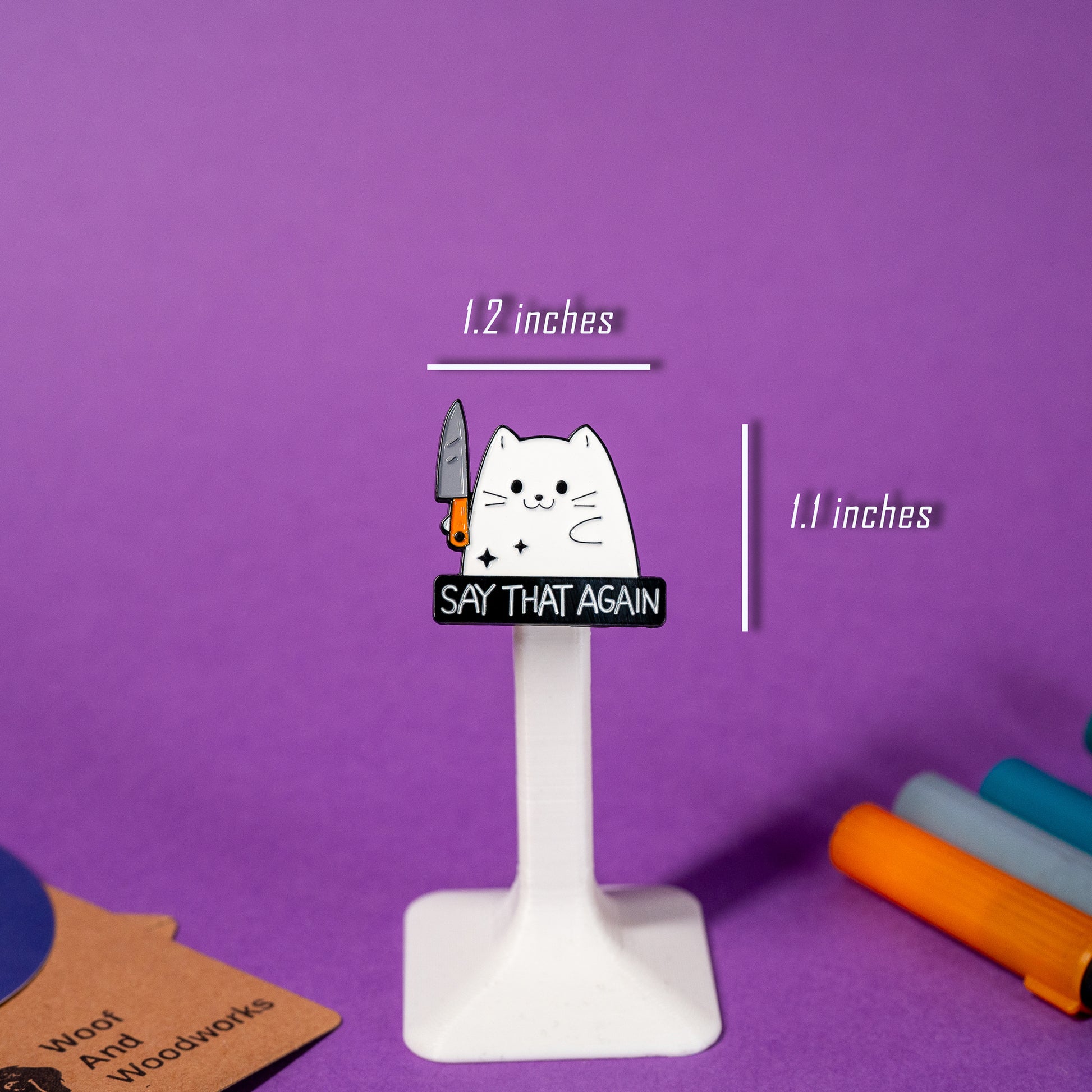 White cat enamel pin holding a knife with the bold text Say That Again, ideal for sarcastic humor lovers.