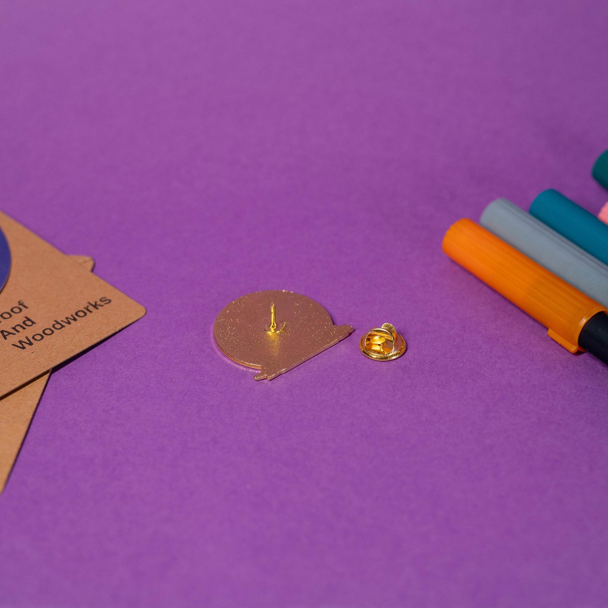 Close-up of a white and gold cat enamel pin showcasing stylish details and humorous text PSPSPSPS.
