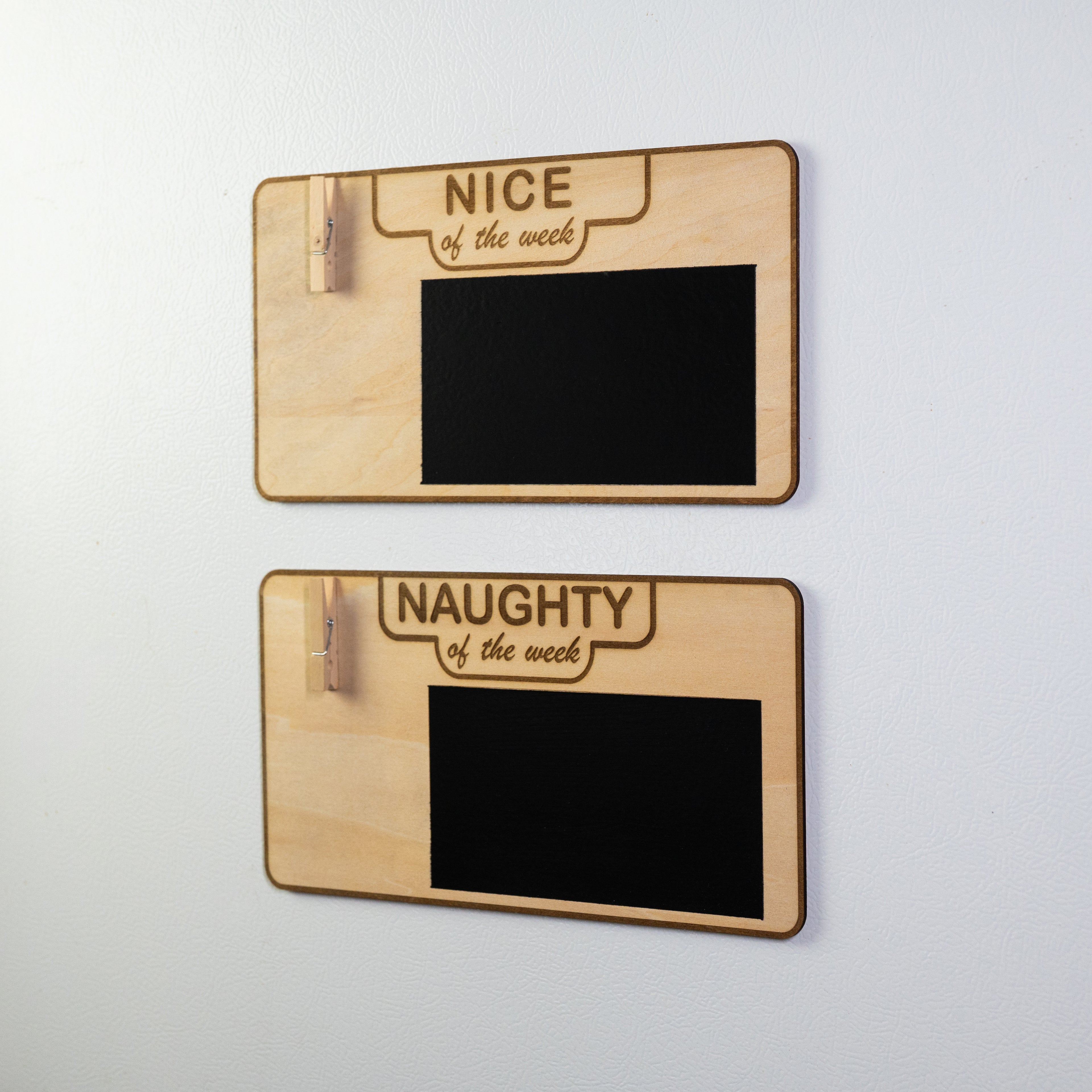 Angled view of empty dog behavior signs on fridge, showing the engraved wood and chalkboard section clearly.