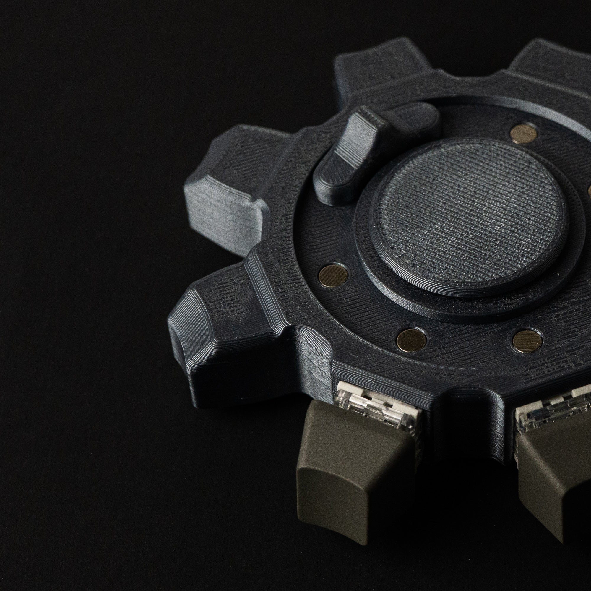 Close-up of mechanical gear fidget showing textured surface, embedded magnets, and precision 3D printed layers.