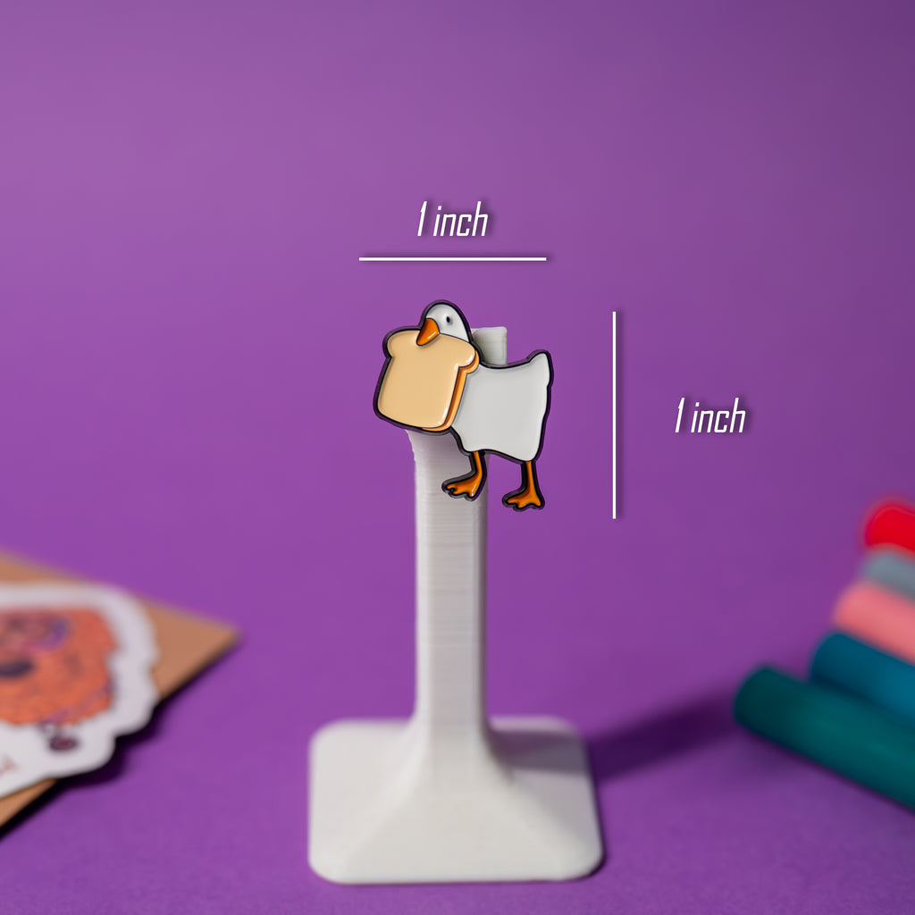 Bread Goose enamel pin with size reference, part of Untitled Goose pin series.