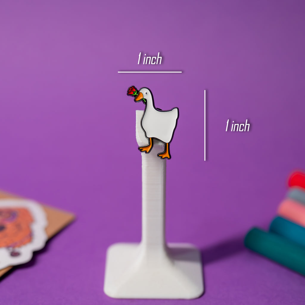 Rose Goose enamel pin with size reference, part of Untitled Goose pin series.