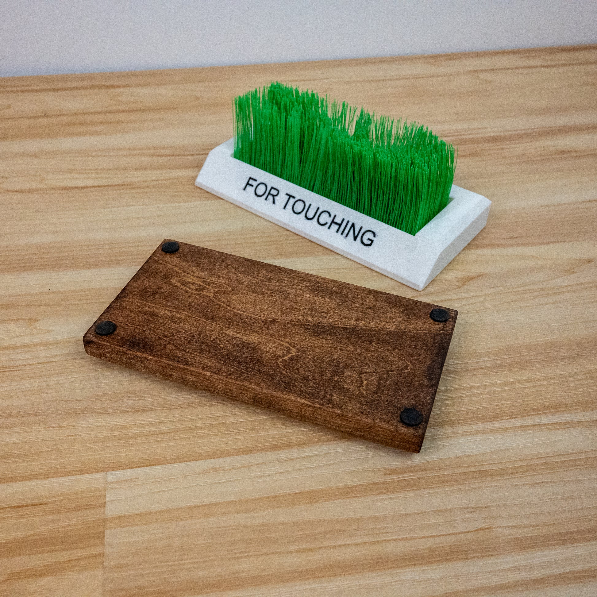Bottom view of touch grass desk accessory showing protective felt pads