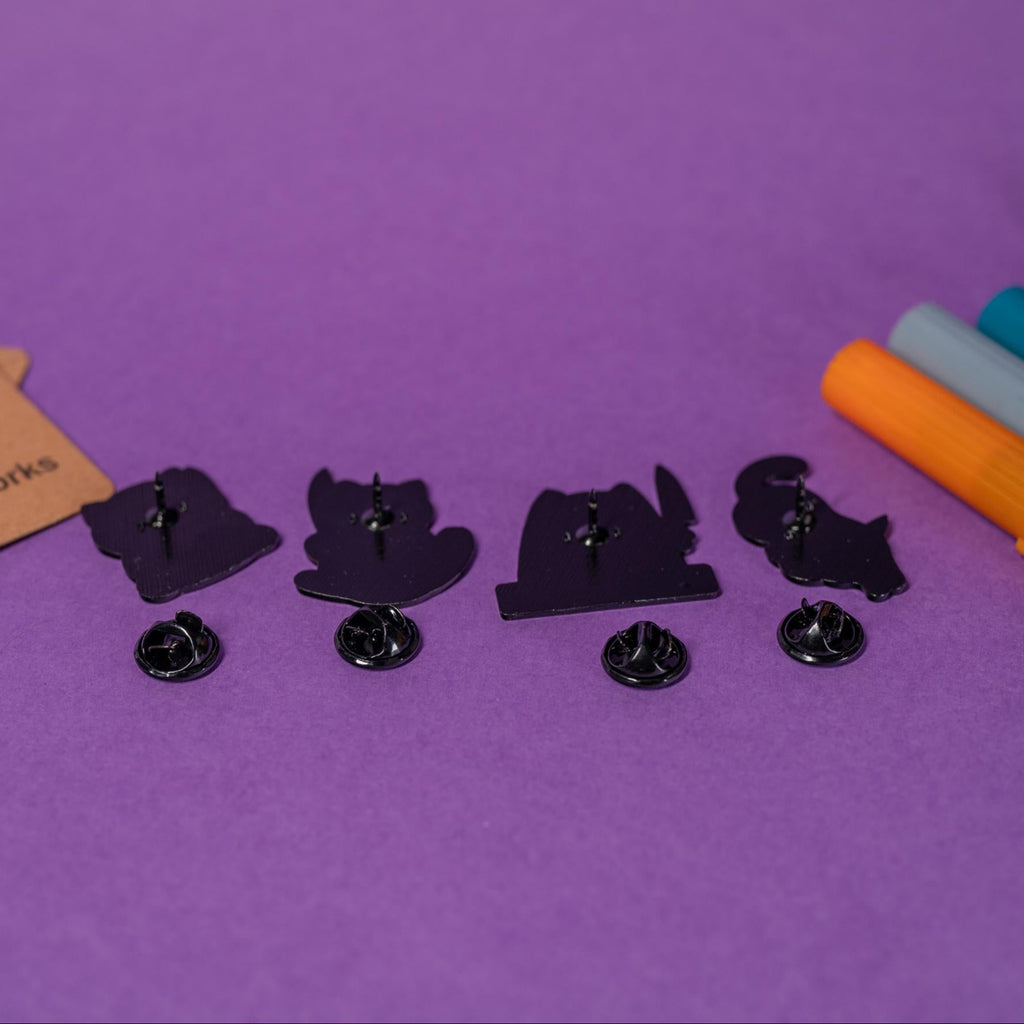 Group photo of 4 funny white cat enamel pins showcasing mischievous and adorable designs.