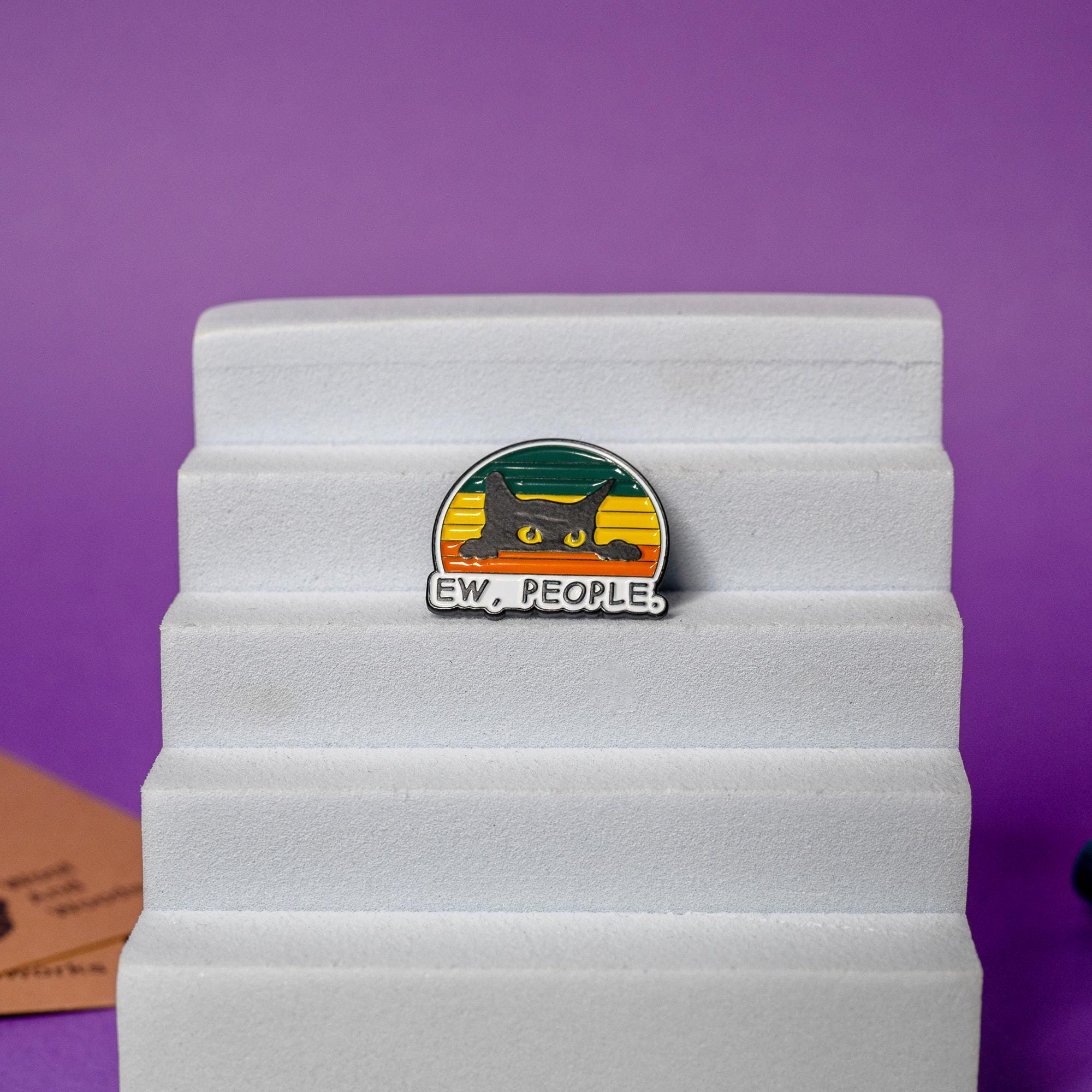 Close-up of black cat enamel pin with the sarcastic text Ew, People perfect for introverts.
