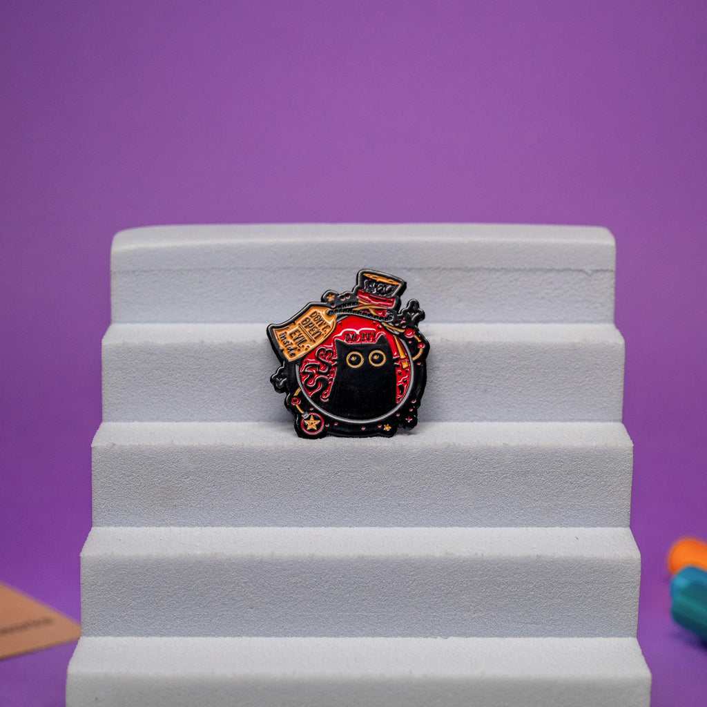 Witchy enamel pin with an alchemy flask, black cat peering out, and a playful warning tag Evil Inside.