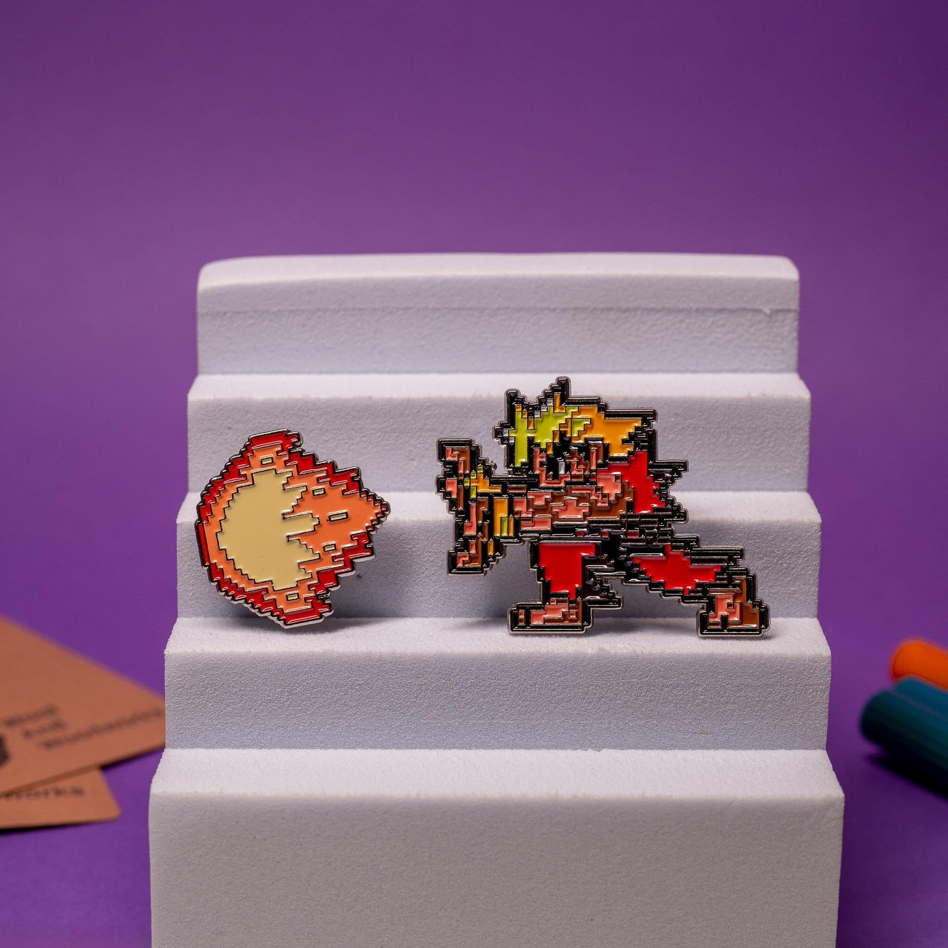 Street Fighter enamel pin set displayed together, featuring Akuma and Ken with their matching fireballs.