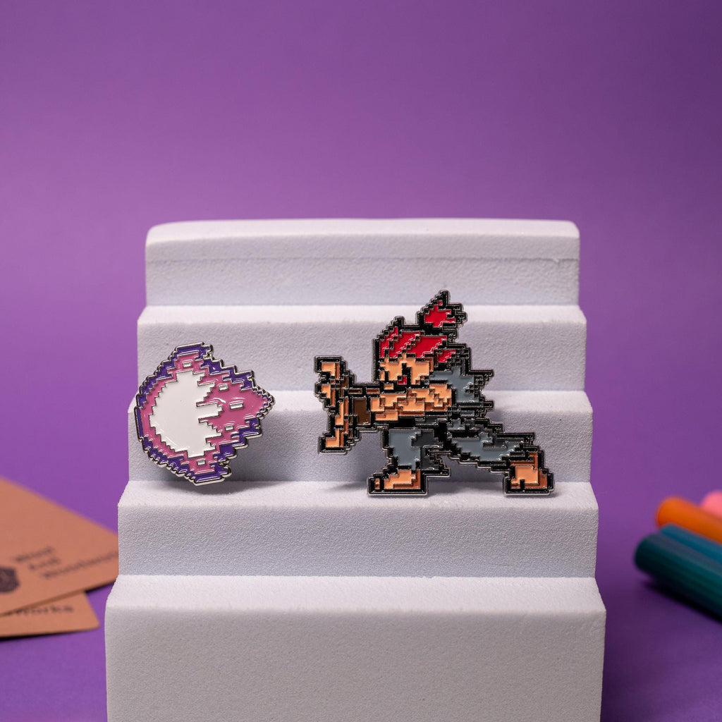 Street Fighter enamel pin set displayed together, featuring Akuma and Ken with their matching fireballs.
