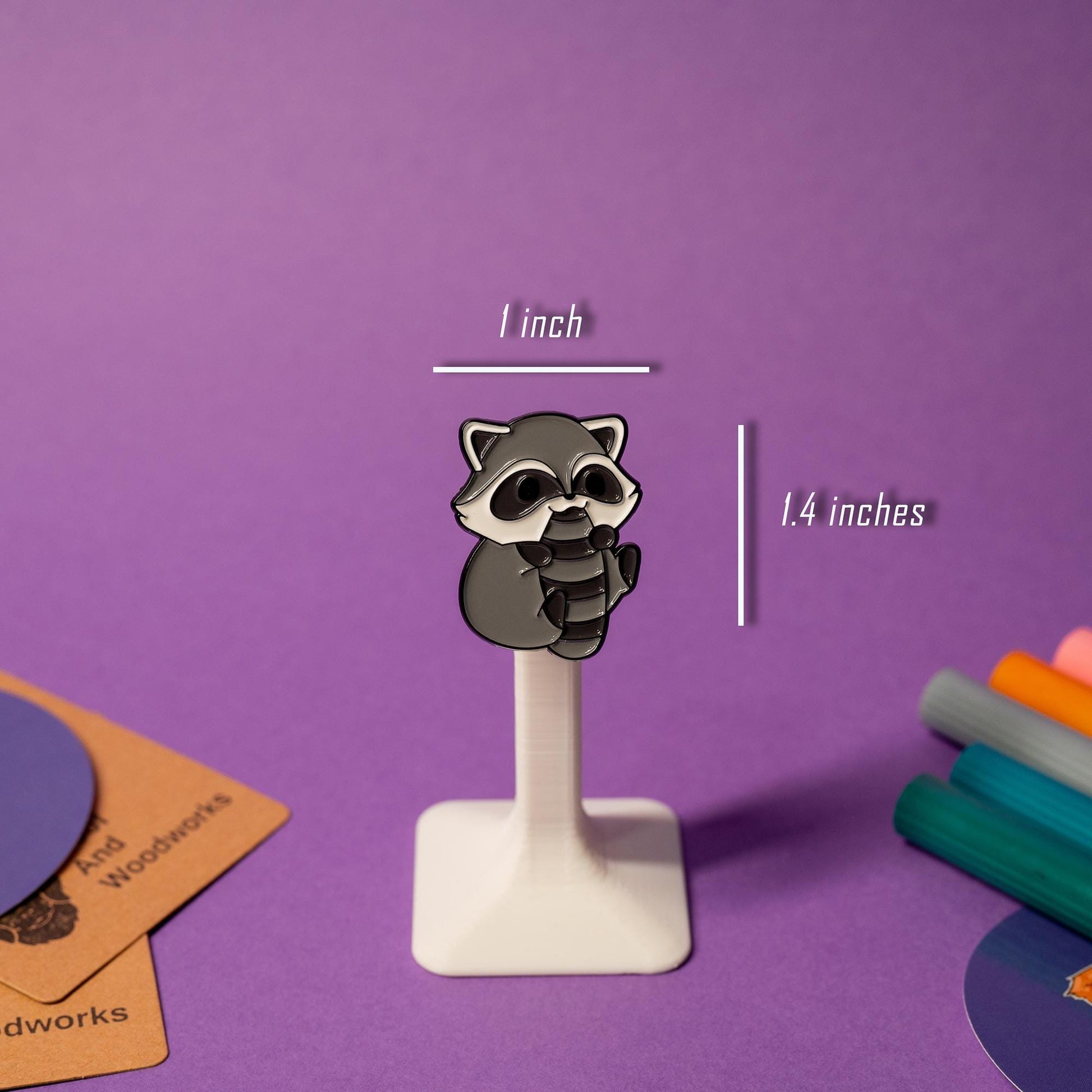 Close-up of raccoon enamel pin showcasing detailed craftsmanship and a glossy, vibrant finish.