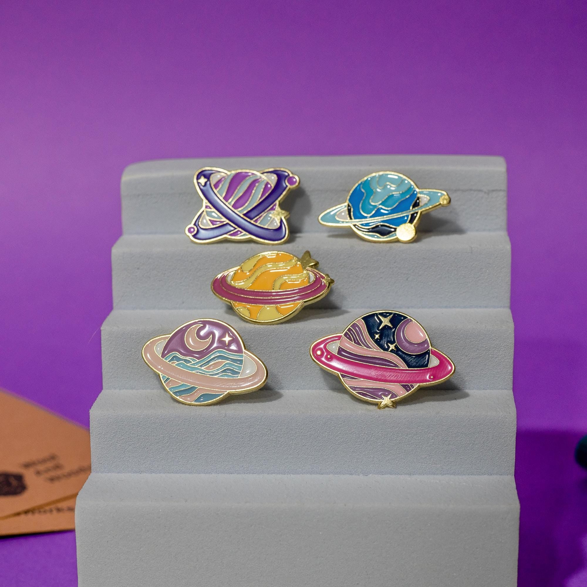 Full view of the fantasy planet enamel pin set with five unique, colorful designs.