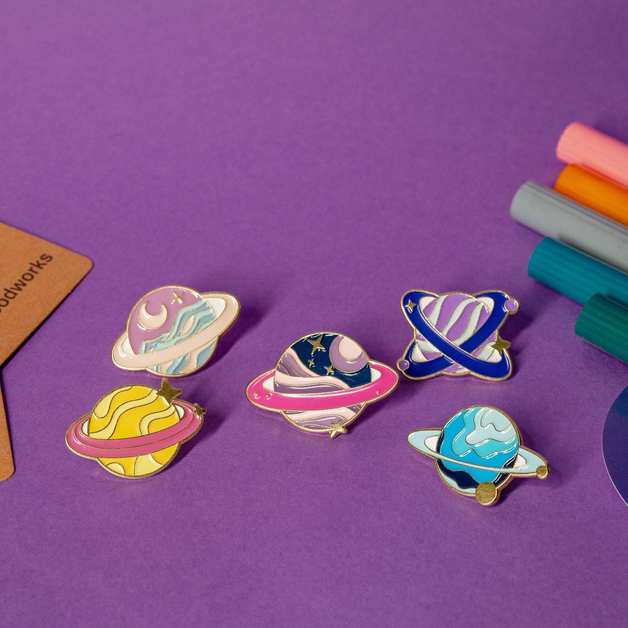 Set of 5 enamel pins featuring colorful fantasy planet designs inspired by a distant galaxy.