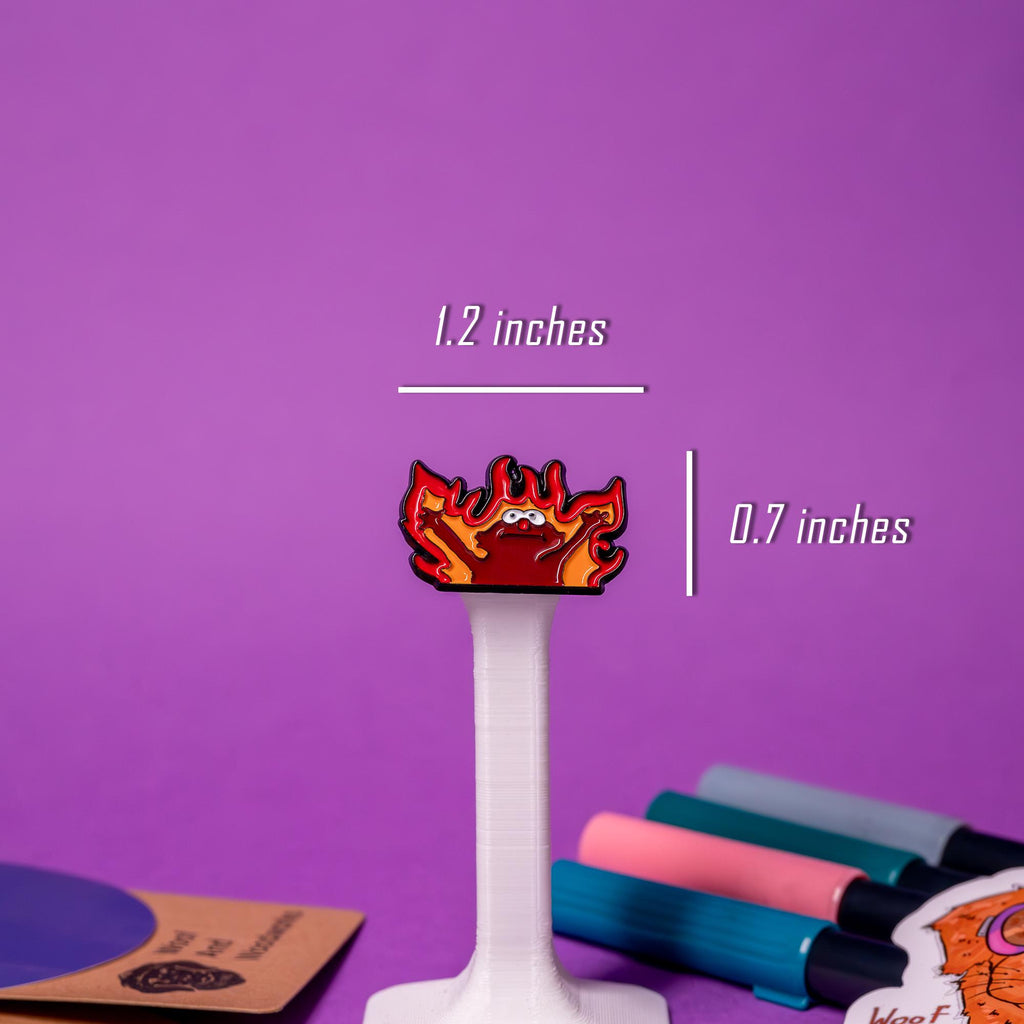 Close-up of the Hellmo enamel pin featuring the iconic fire puppet meme, showcasing bright red and orange flames with bold detailing.