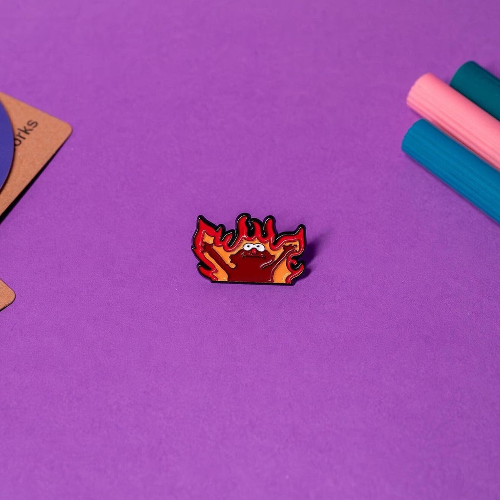 Funny enamel pin of Hellmo, the fire puppet meme, perfect for collectors and fans of quirky accessories.