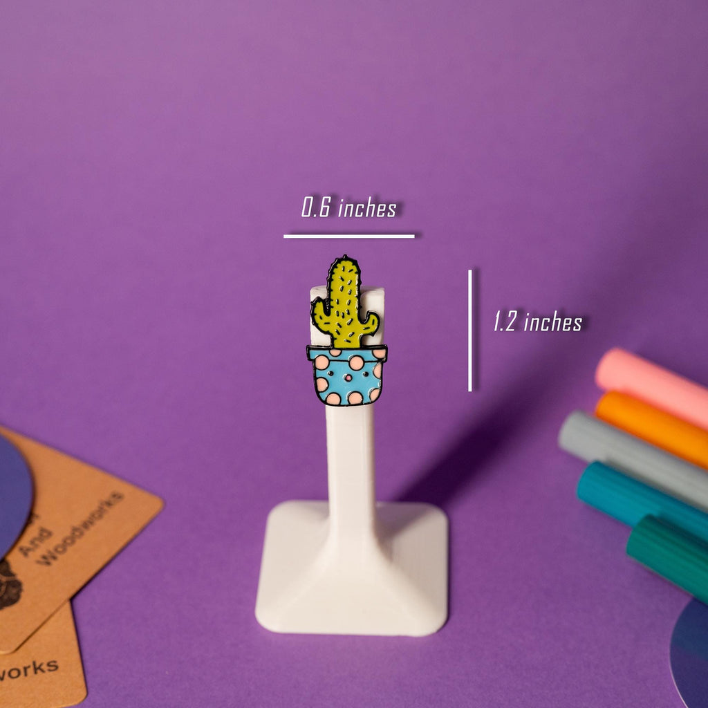 A prickly but adorable cactus enamel pin with a sweet expression.