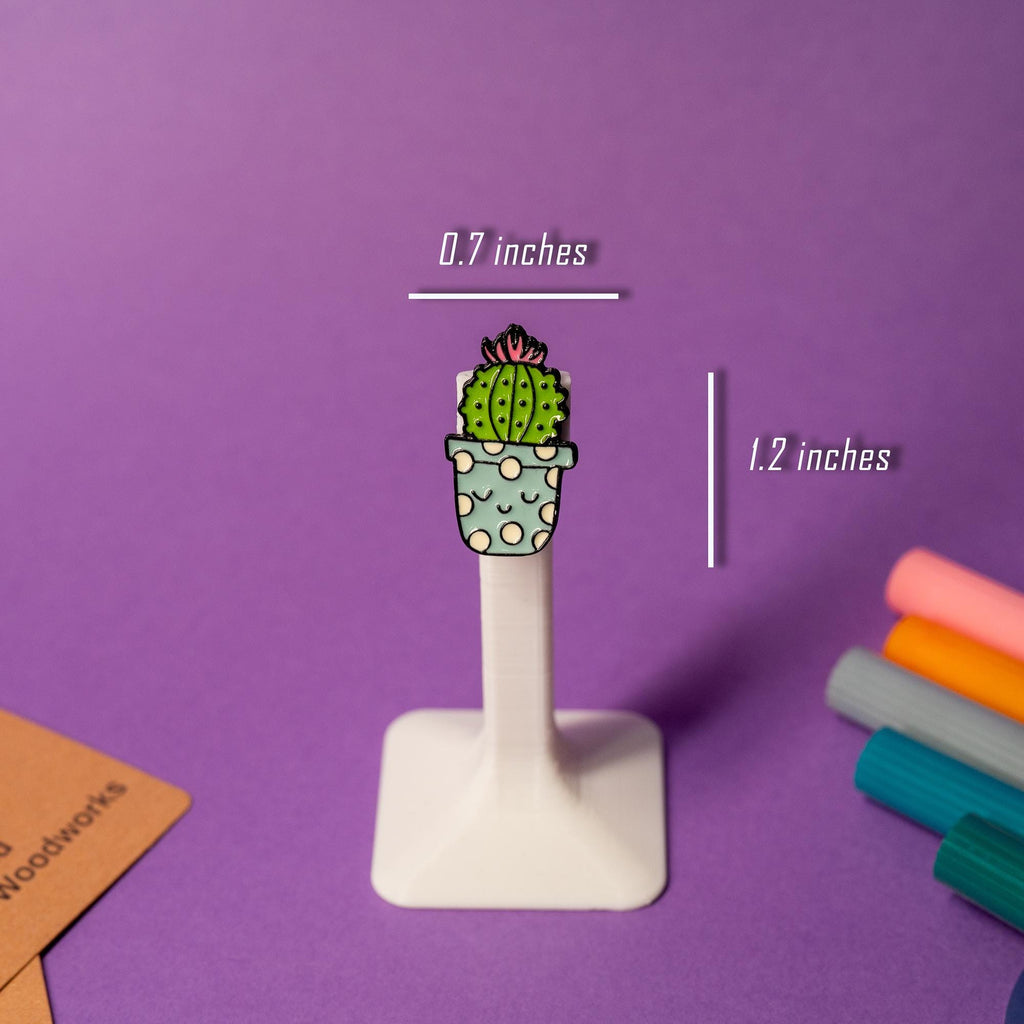 A prickly but adorable cactus enamel pin with a sweet expression.