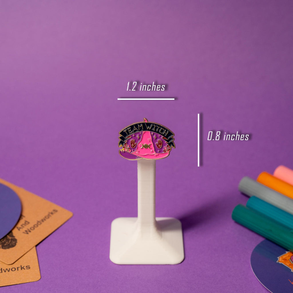 Purple-pink enamel pin featuring a witch hat with the empowering phrase Team Witch.