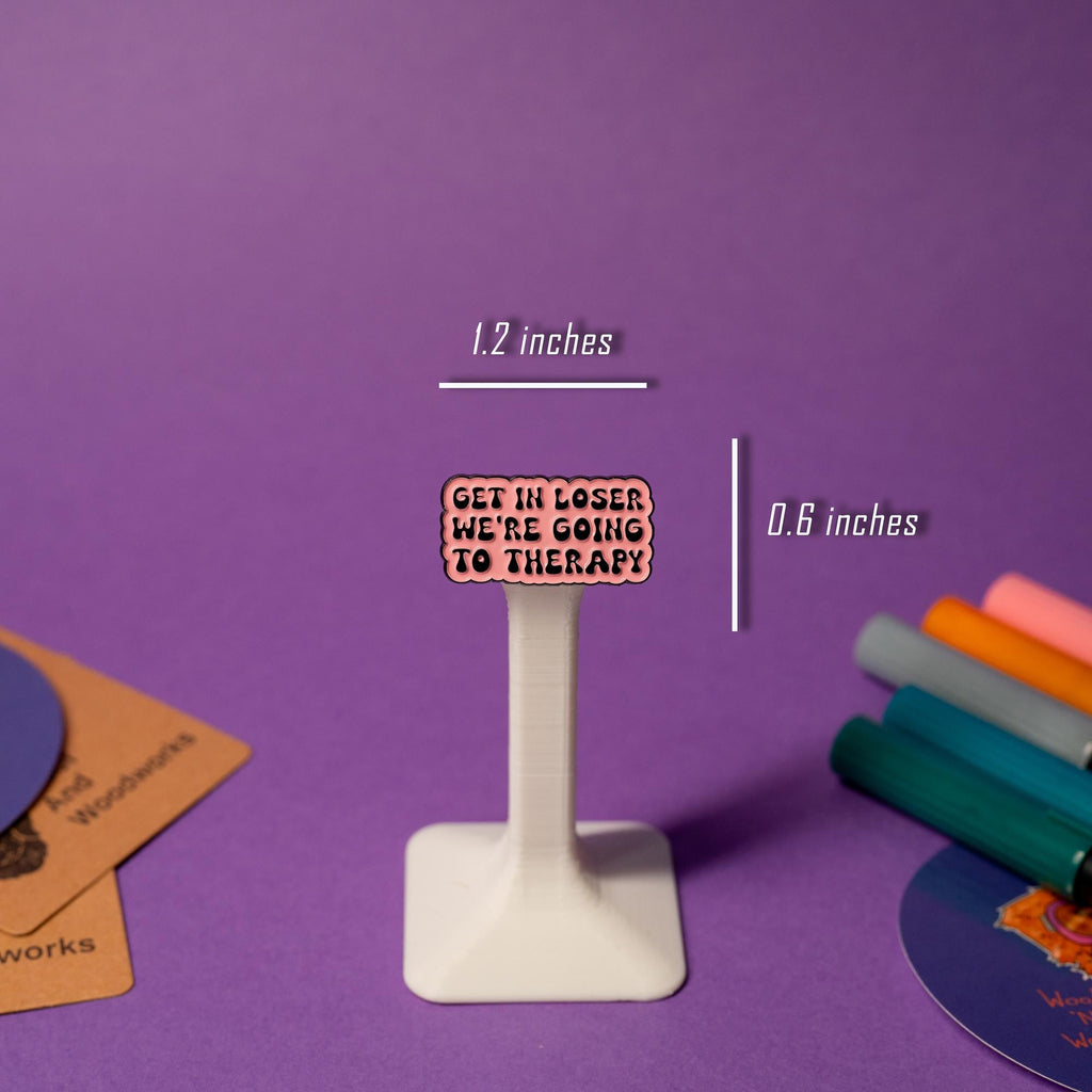 Enamel pin with the phrase Get In Loser, We’re Going to Therapy, in bold, clean lettering.