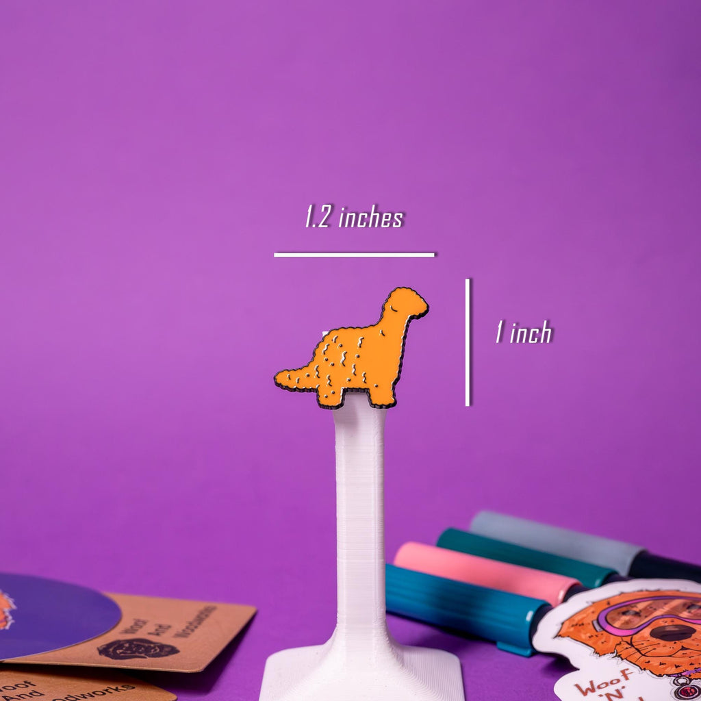 Close-up of the brachiosaurus dino nugget enamel pin, showcasing its long neck and quirky nugget-inspired details.