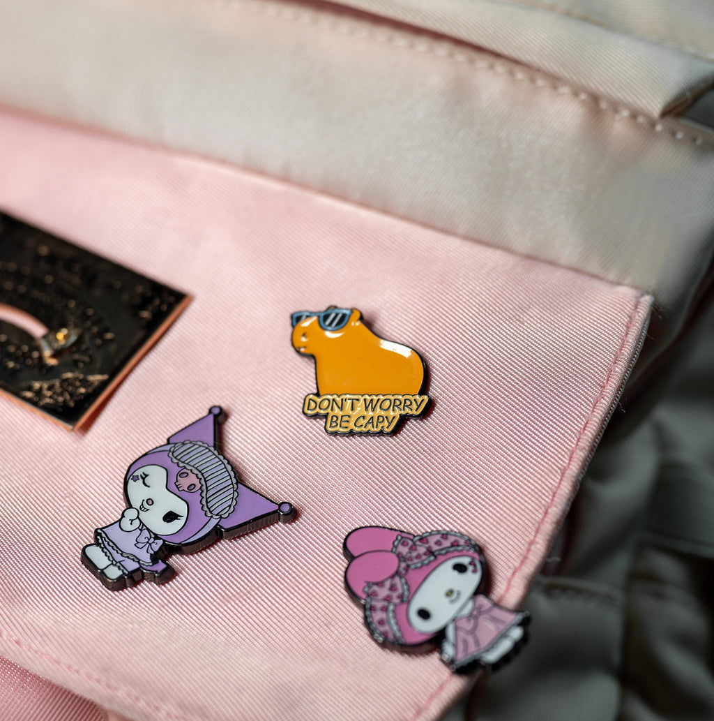 Friendly Capybara enamel pin displayed on a backpack, showcasing its bright colors and cute capybara design in everyday use.