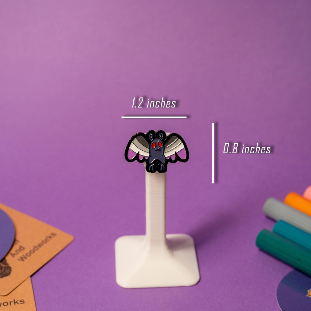 Close-up of Mothman enamel pin with Asexual pride flag design, ideal for cryptid enthusiasts celebrating their identity.