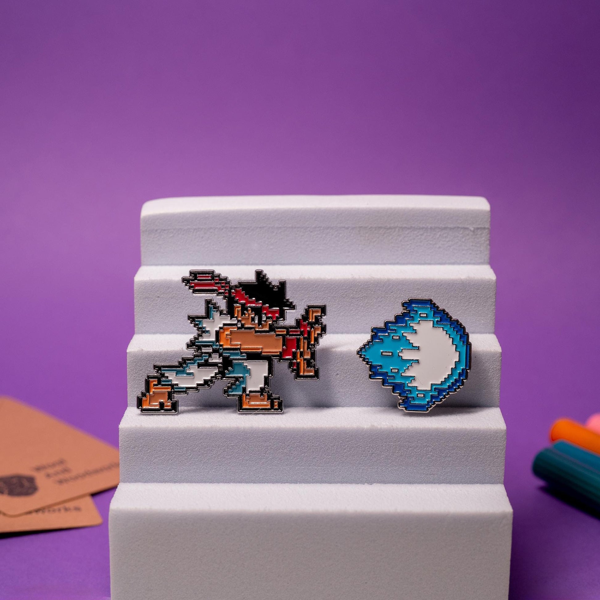 Street Fighter enamel pin set displayed together, featuring Akuma and Ken with their matching fireballs.