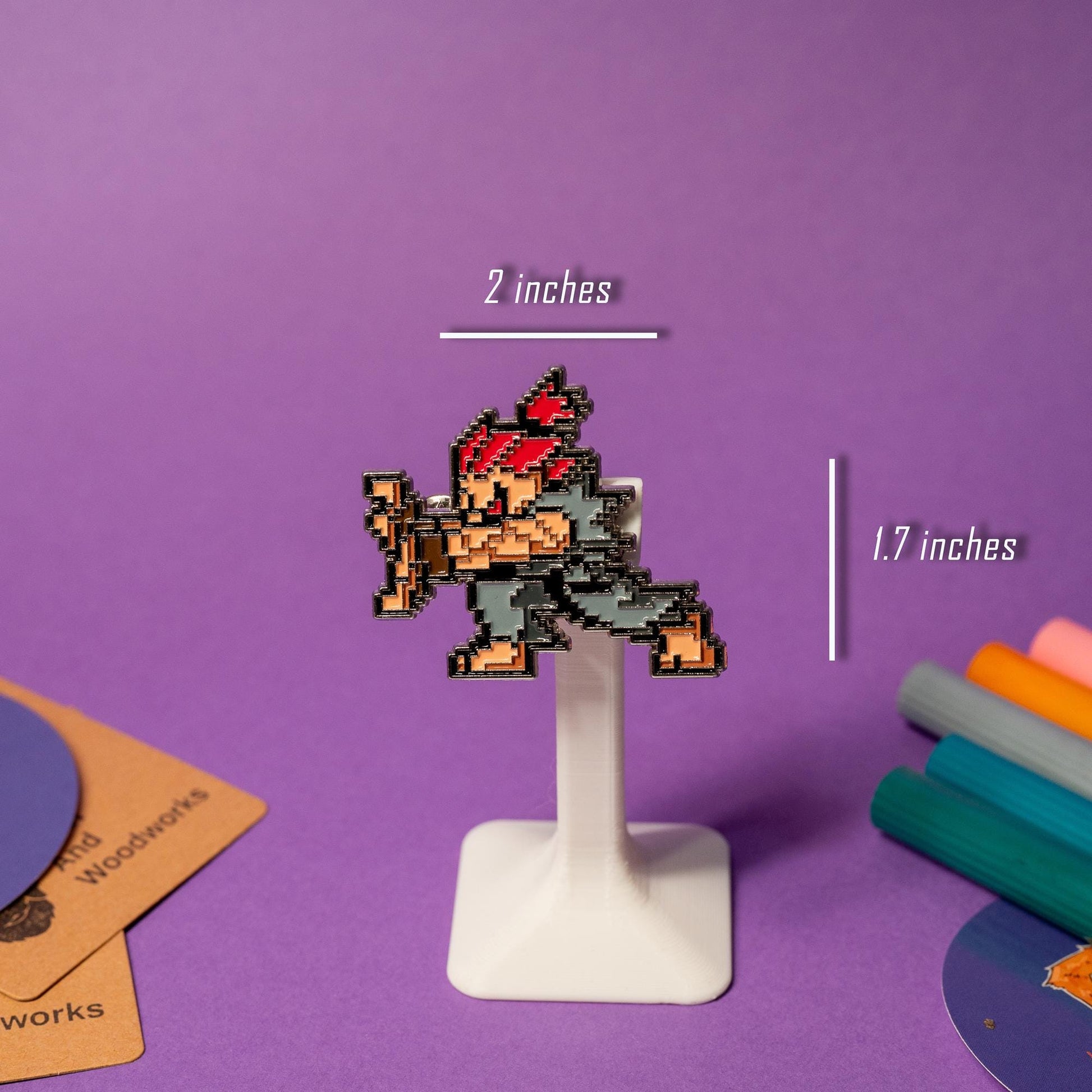 Close-up of pixel art enamel pin from the Street Fighter pin set, paired with his fireball pin.