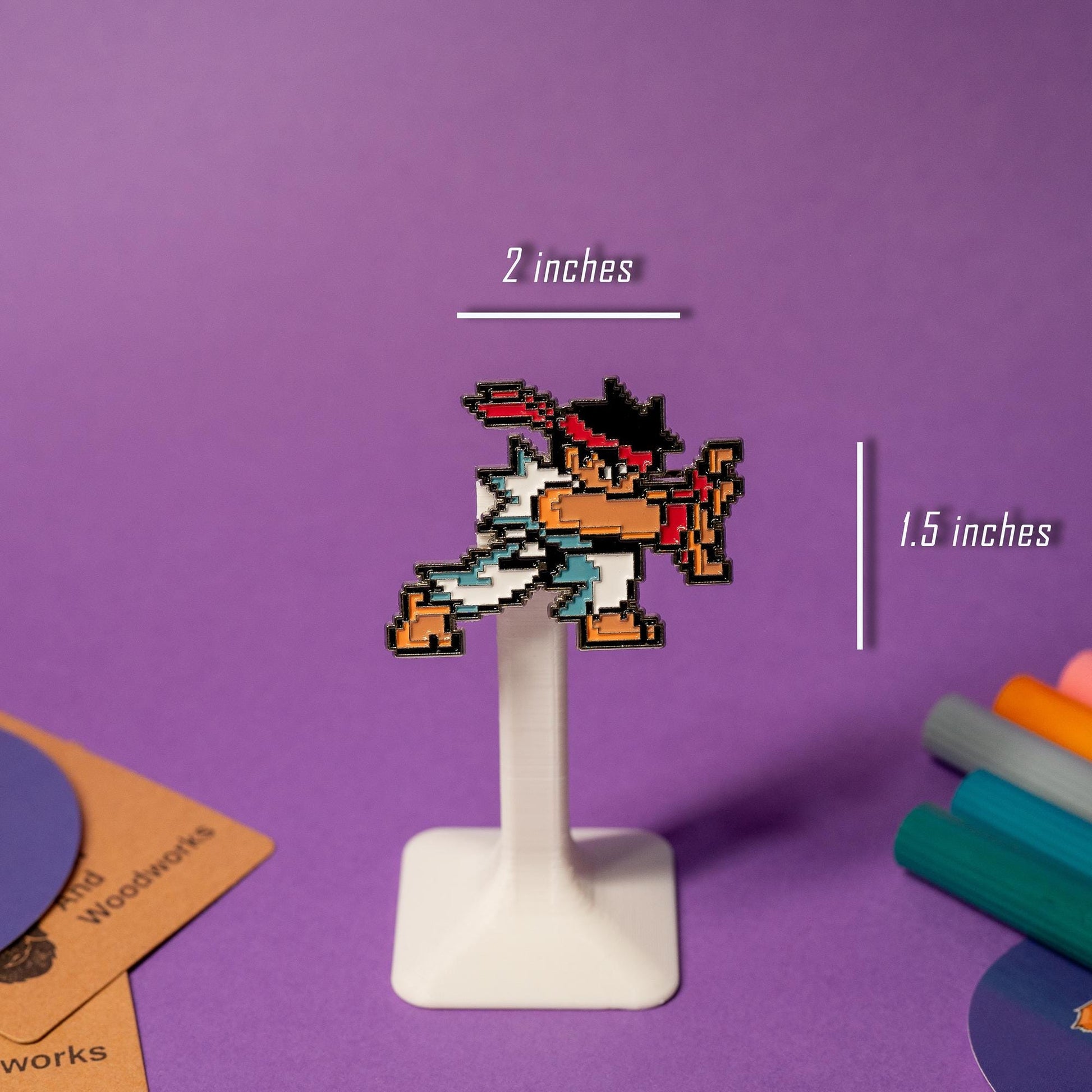 Close-up of pixel art enamel pin from the Street Fighter pin set, paired with his fireball pin.