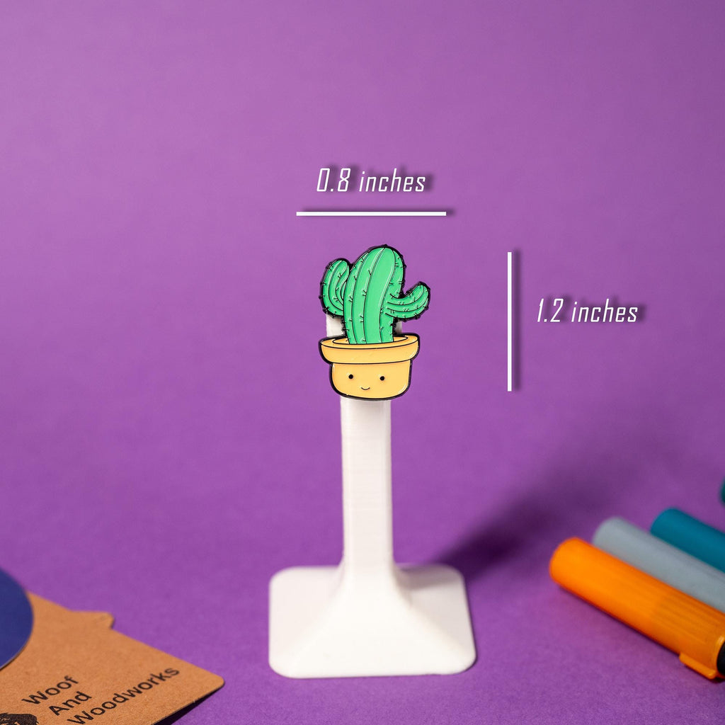 Enamel pin featuring a cheerful potted cactus with a happy smile, perfect for plant lovers.
