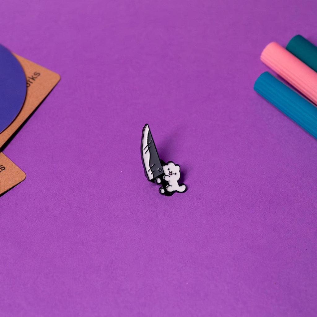 Front view of the Knife Cat enamel pin featuring a playful design of a mischievous cat holding a knife, perfect for cat lovers and humor enthusiasts.