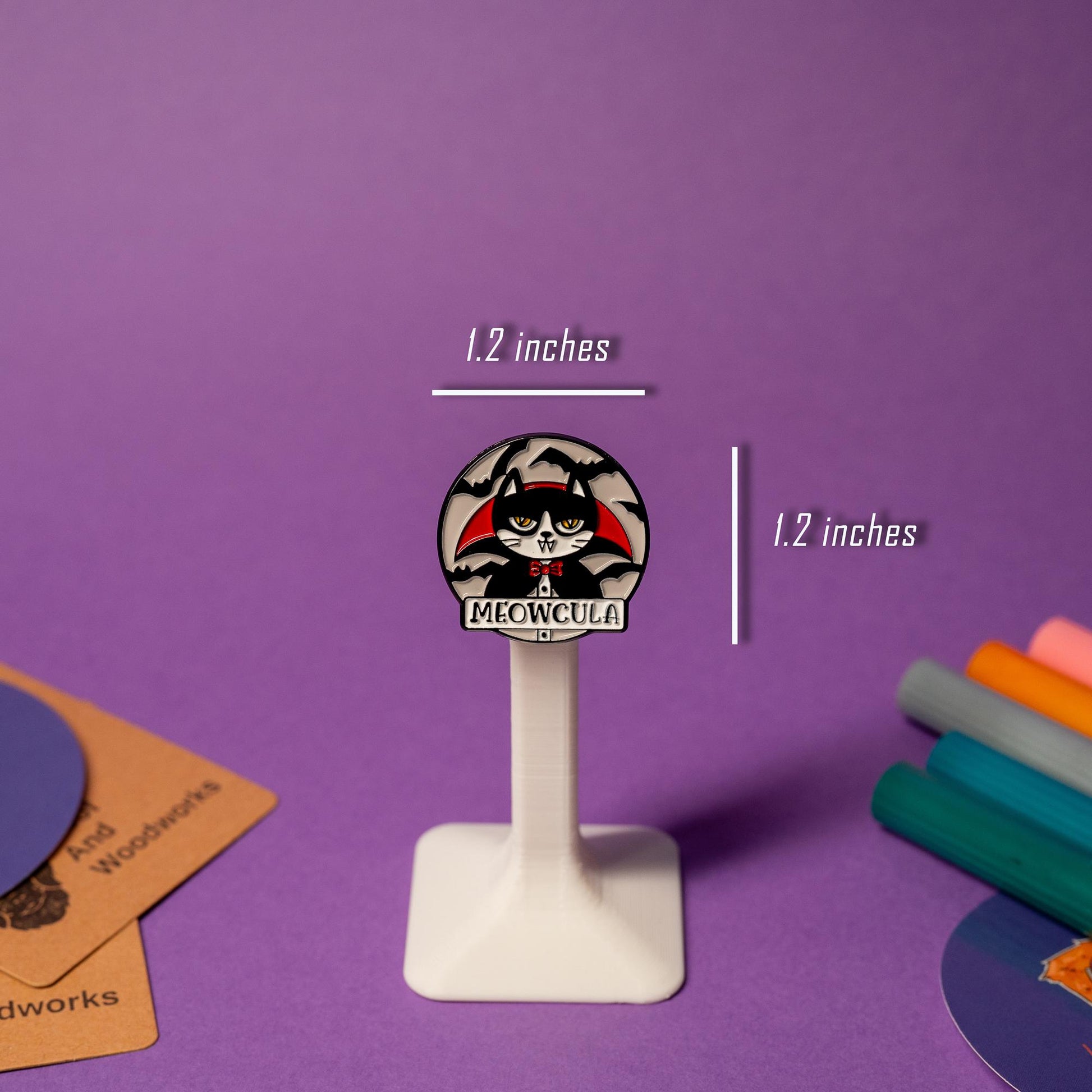 Cat-vampire enamel pin with bats flying around and the pun-filled text Meowcula, ideal for Halloween vibes.