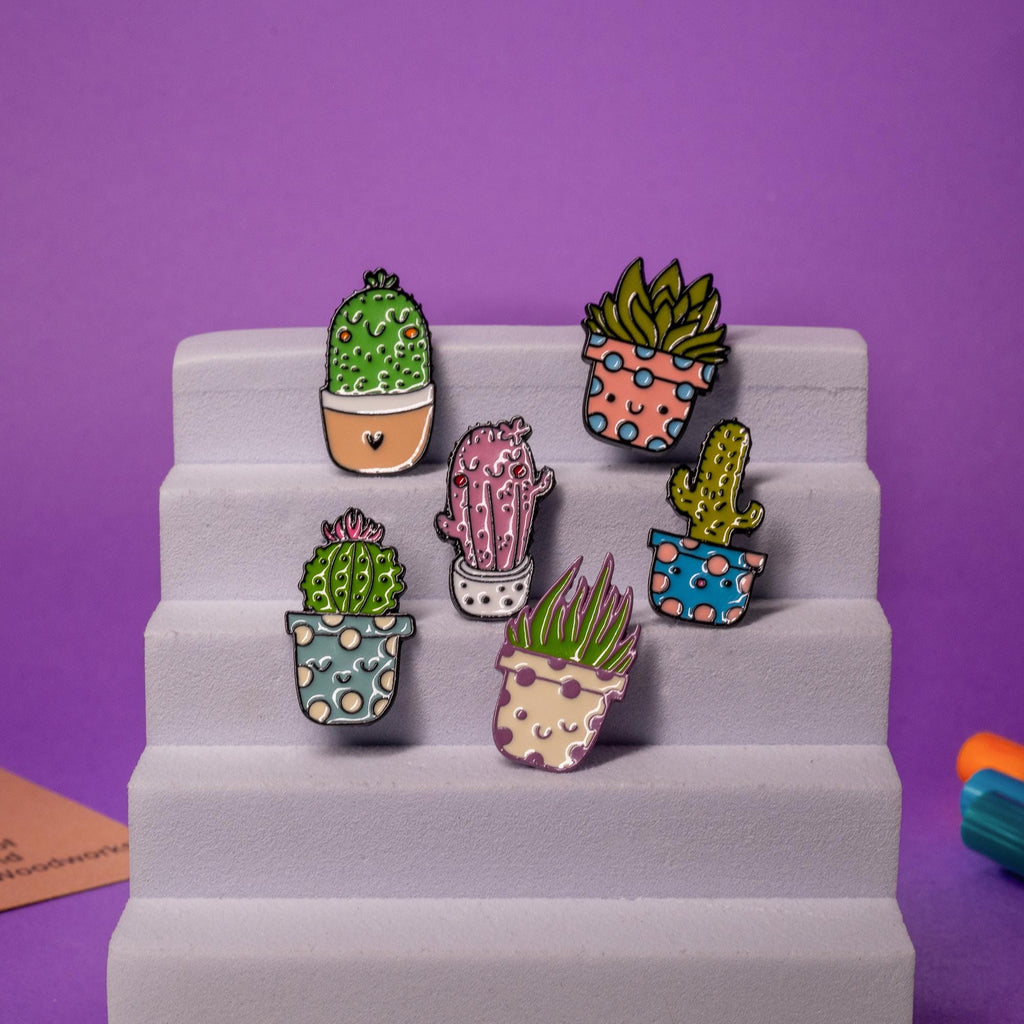 Complete collection of cactus enamel pins with six unique, cheerful designs for plant lovers.