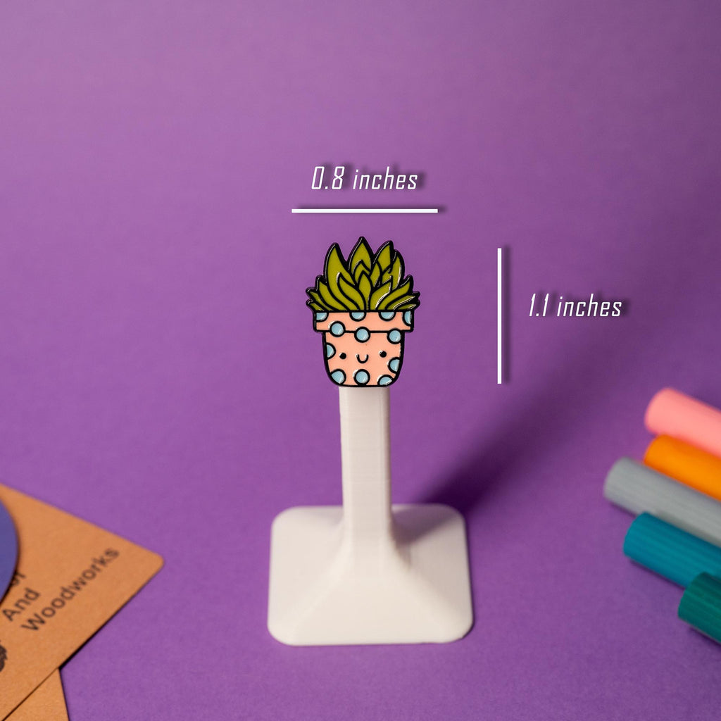 A prickly but adorable cactus enamel pin with a sweet expression.