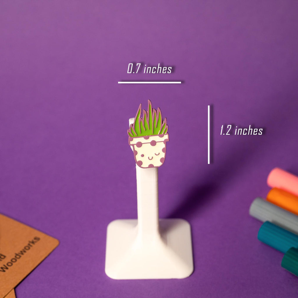 A potted cactus enamel pin with a kawaii-style face and bold colors.
