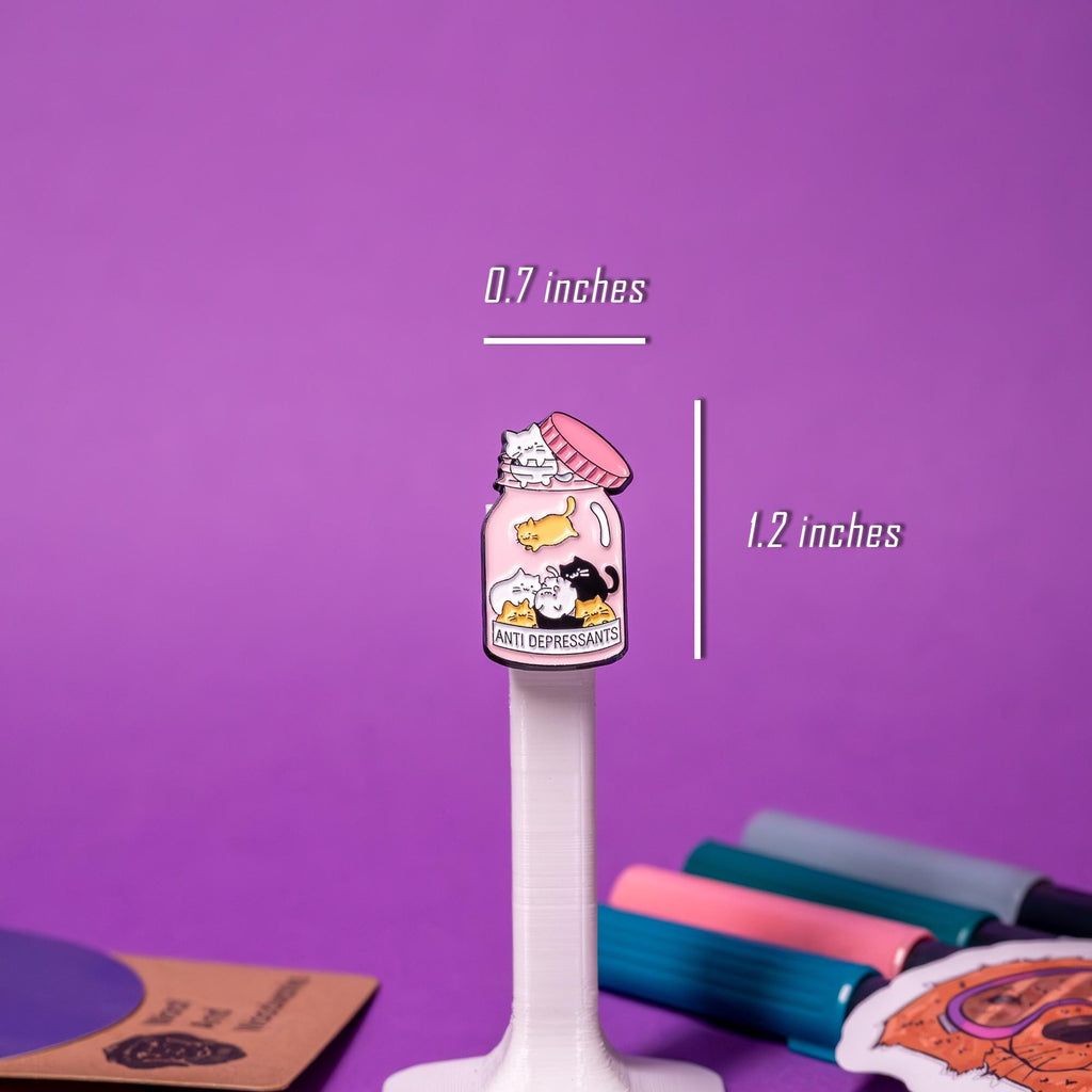 Close-up of the &#39;Anti Depressants&#39; enamel pin, showcasing intricate details of the bottle, text, and cute cats inside.