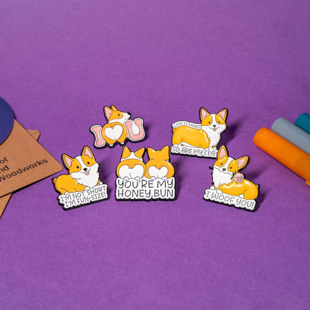 Set of 5 corgi enamel pins featuring funny and adorable designs: I Woof You, Life Is Short, Honey Bun, Fun-Size, and I Love U.